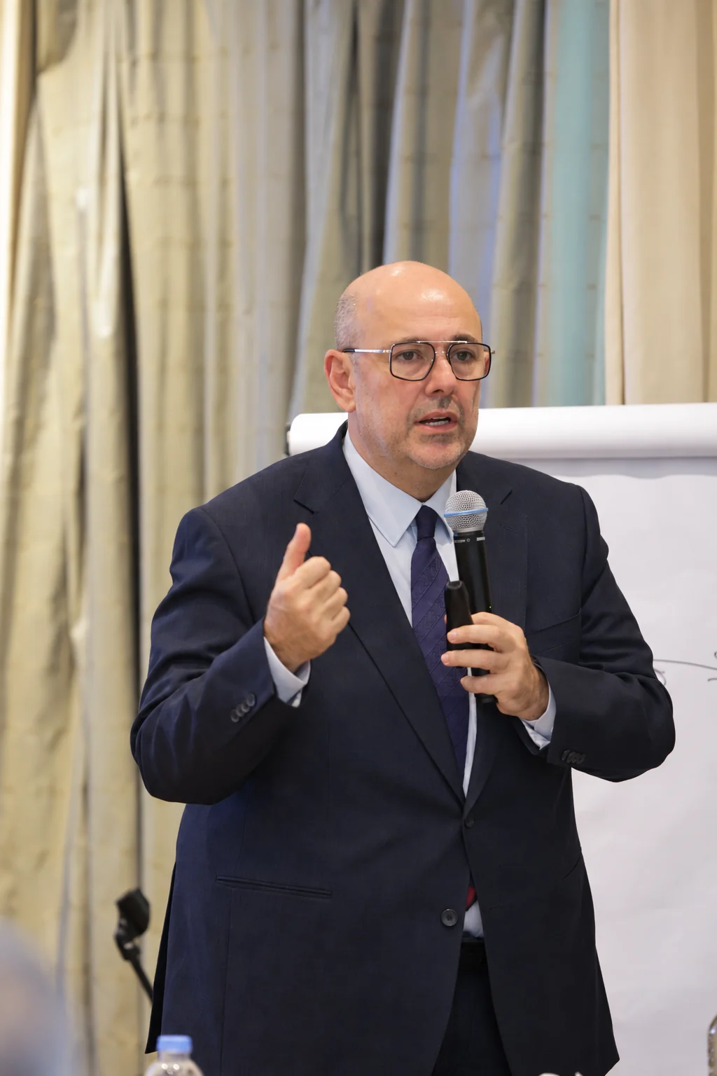 An instructor leading a Headway executive course with a microphone